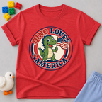 Dino Loves America Shirt Christian kids shirt in red featuring a dinosaur holding an American flag

