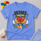 Jesus Holds My Heart Christian kids shirt in blue featuring a smiling heart with faith-inspired typography
