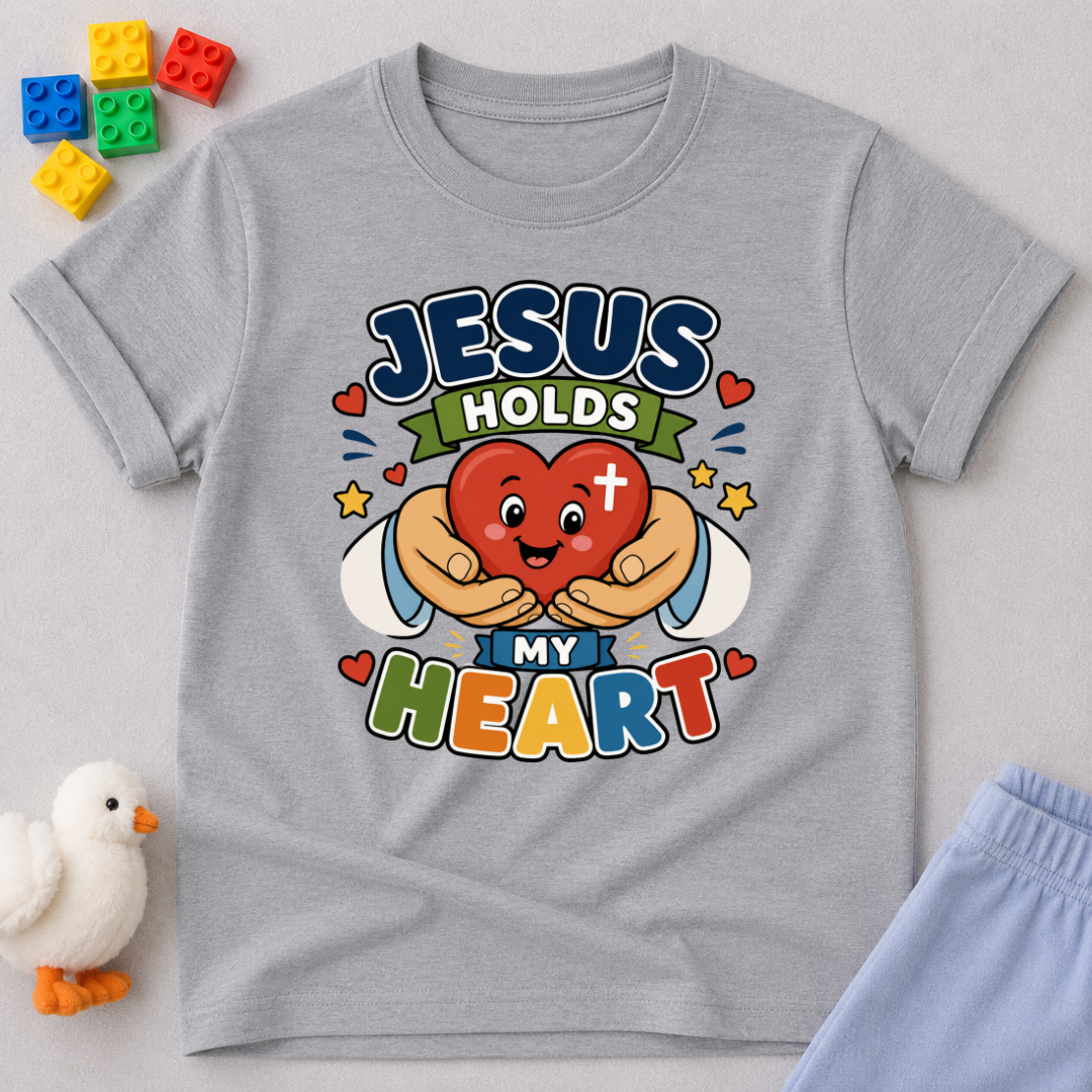 Jesus Holds My Heart Christian kids shirt in gray featuring a smiling heart with faith-inspired typography
