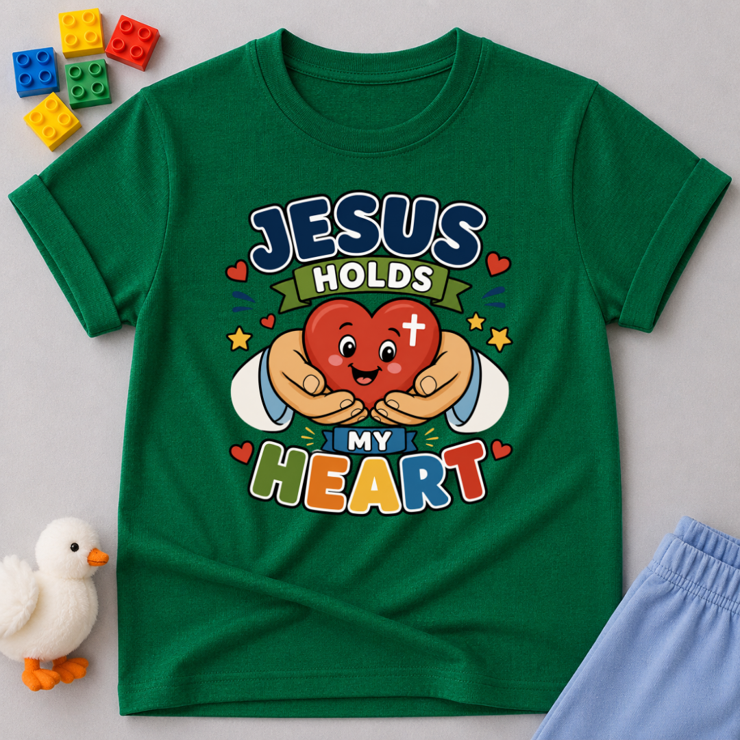 Jesus Holds My Heart Christian kids shirt in green featuring a smiling heart with faith-inspired typography
