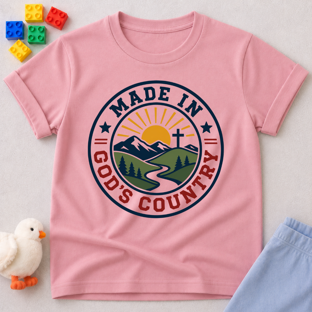 Made in God's Country Shirt Christian kids shirt in pink featuring mountains, a cross, and patriotic artwork

