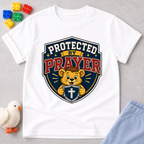 Protected by Prayer Shield Christian kids shirt in white featuring a lion inside a protective shield
