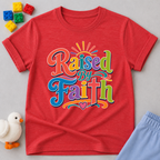 Raised by Faith Typography Christian kids shirt in red featuring colorful faith-inspired lettering
