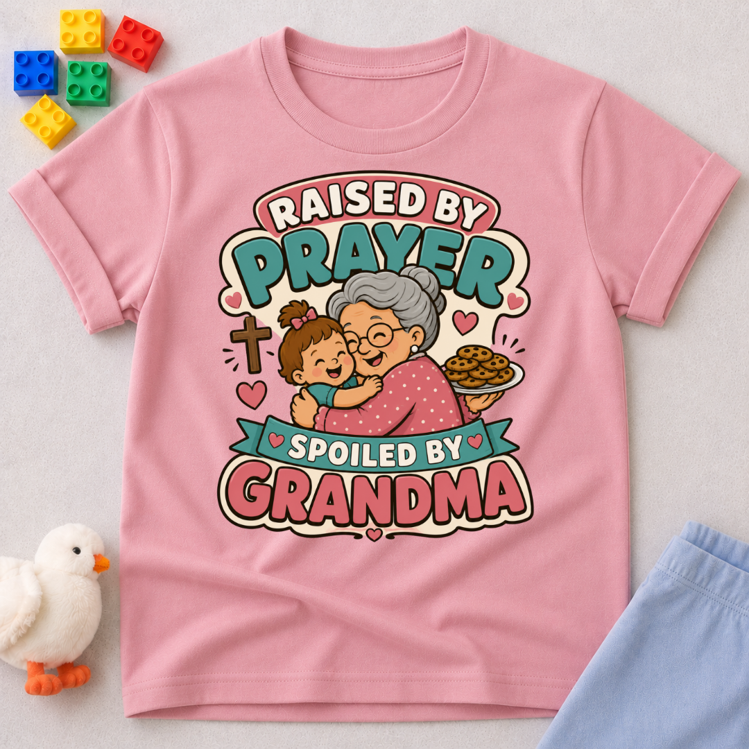 Raised by Prayer Spoiled by Grandma Christian kids shirt in pink featuring a grandmother hugging a child
