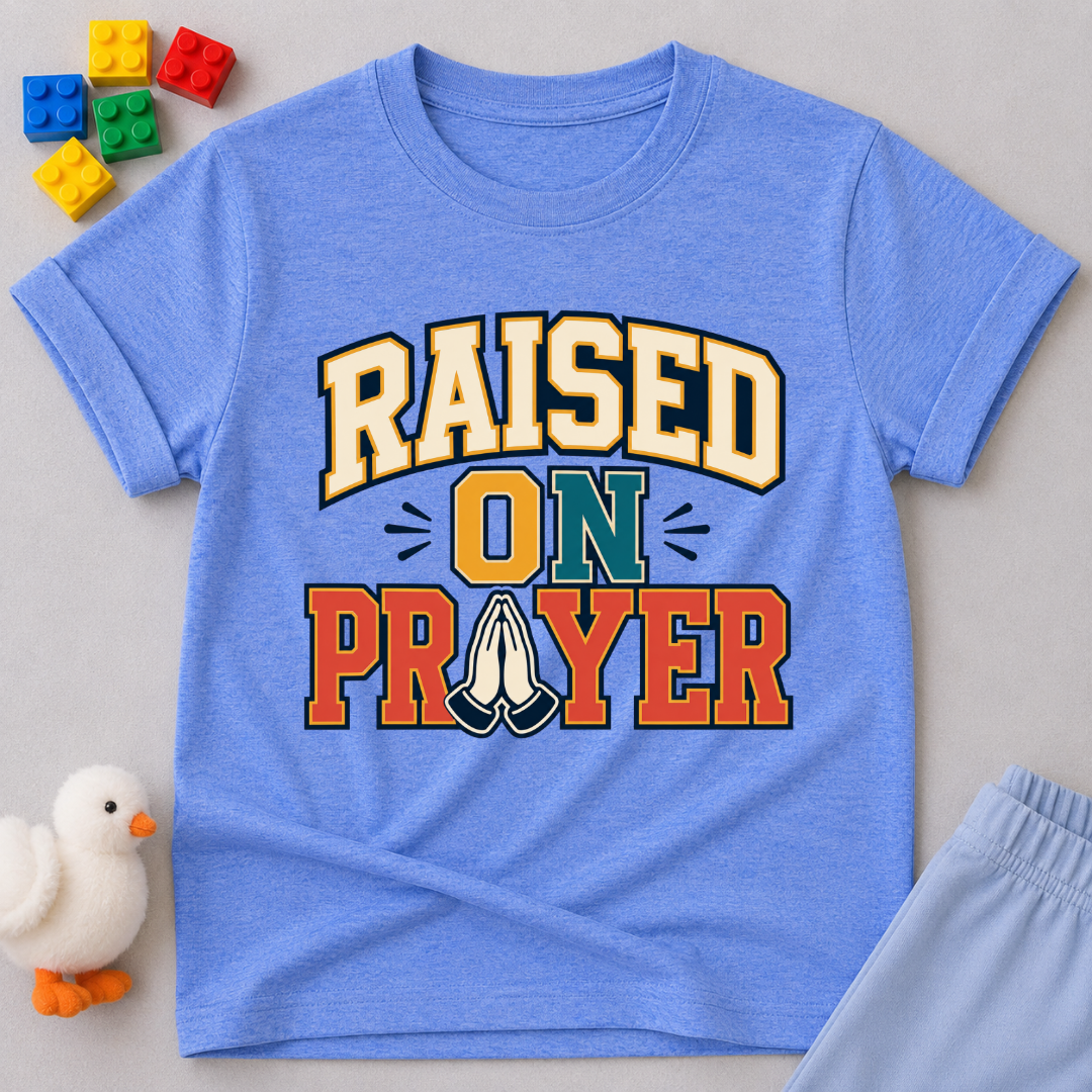 Raised on Prayer Christian kids shirt in blue featuring bold typography and praying hands
