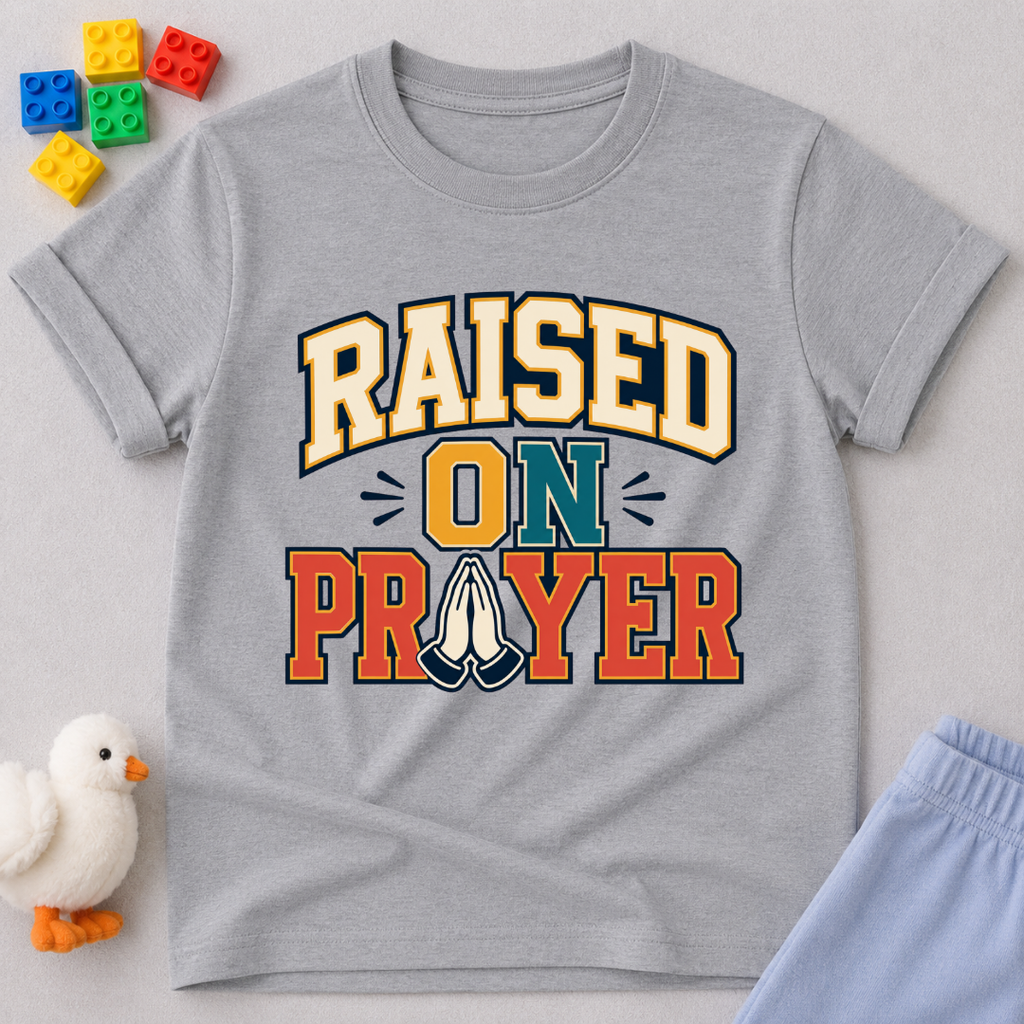 Raised on Prayer Christian kids shirt in gray featuring bold typography and praying hands
