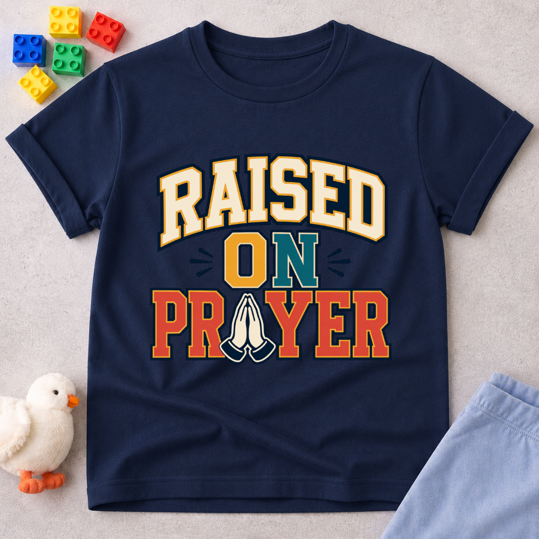 Raised on Prayer Christian kids shirt in navy featuring bold typography and praying hands
