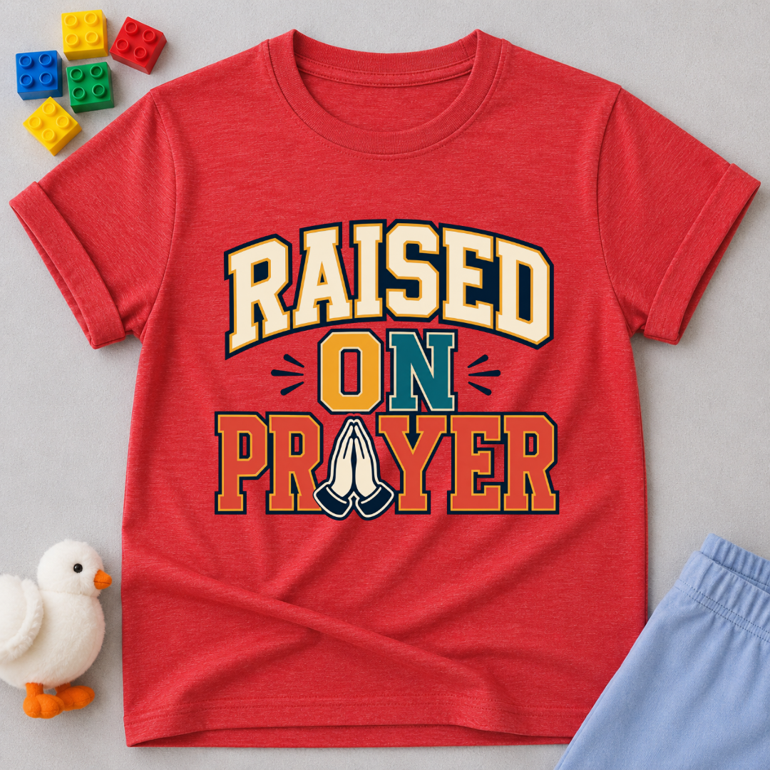 Raised on Prayer Christian kids shirt in red featuring bold typography and praying hands
