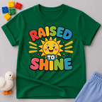 Raised to Shine Christian kids shirt in green featuring a smiling sunshine with colorful uplifting typography

