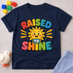 Raised to Shine Christian kids shirt in navy featuring a smiling sunshine with colorful uplifting typography
