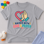 Raised with Love and Prayer Christian kids shirt in gray featuring praying hands and heart artwork
