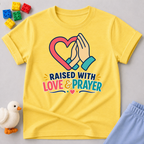 Raised with Love and Prayer Christian kids shirt in yellow featuring praying hands and heart artwork
