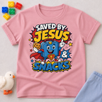 Saved by Jesus and Snacks Christian kids shirt in pink featuring a smiling superhero snack character

