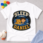 Sleep Like Daniel Christian kids shirt in white featuring a sleeping child and lion under the stars
