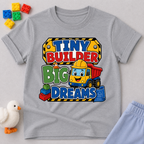 Tiny Builder Big Dreams Christian kids shirt in gray featuring a cheerful construction vehicle
